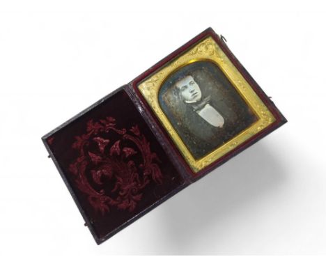 A Victorian Daguerrotype portrait, half length, of a young man in embossed leather case; a slightly larger Daguerrotype portr