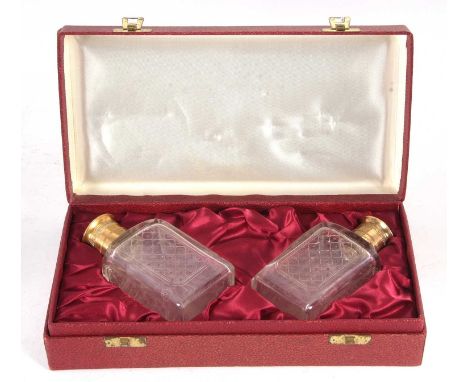 A cased pair of Asprey &amp; Co cologne bottles, the glass etched bodies with gilt metal collars and pull off silver-gilt top