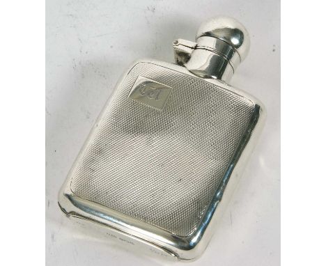 An Art Deco silver small spirit flask of shaped rectangular form, engine turned decorated front and back and initialled to on