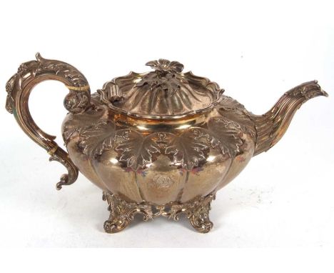 A William IV melon shaped teapot with leaf scroll handle and flower head finial, fluted body with chased decorated leaf shoul