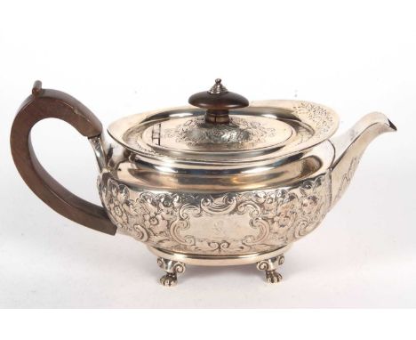 A George III silver teapot of oval form and elaborately decorated with scrolled flowers, travelling leaves etc, having a tree