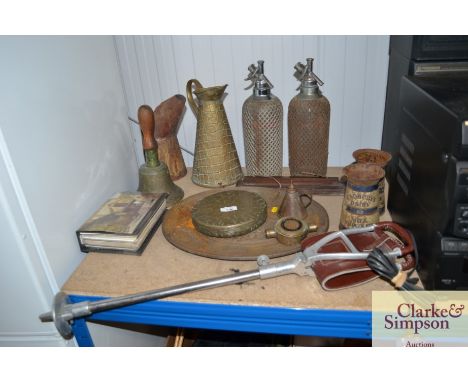 A quantity of various brassware to include a dinner gong lacking stand; soda siphons; brass jug; vintage Cadburys Dairy Milk 