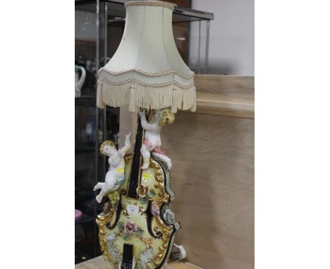 A LARGE DECORATIVE CONTINENTAL STYLE LAMP IN A FORM OF A VIOLIN AND TWO CHERUB FIGURES 