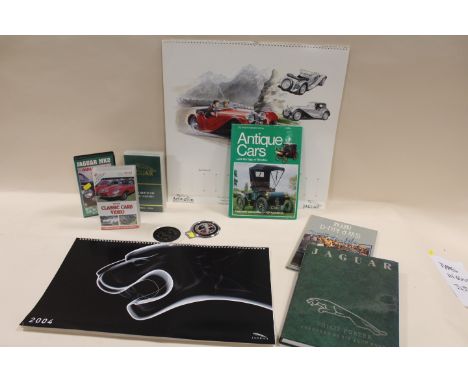 A COLLECTION OF VINTAGE JAGUAR MEMORABILIA TO INCLUDE A JAGUAR DRIVERS CLUB CAR BADGE, VARIOUS BOOKS,  CALENDARS AND VHS ETC