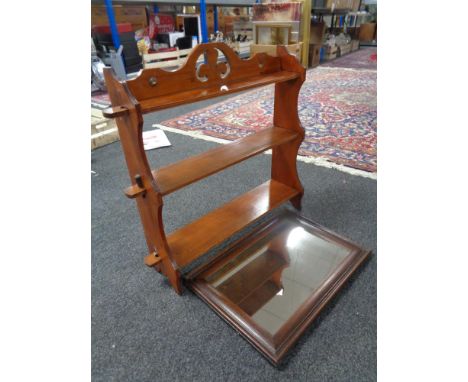 An Edwardian mahogany wall shelf (missing 3 pegs) and an oak framed mirror 