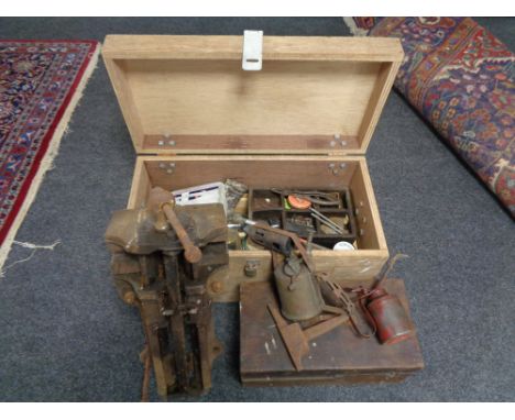 A plywood tool box of hard ware, oil cans, vintage blow lamp, a further tool box and a heavy duty bench vice 