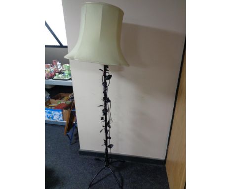 A wrought metal standard lamp of flower design with shade 