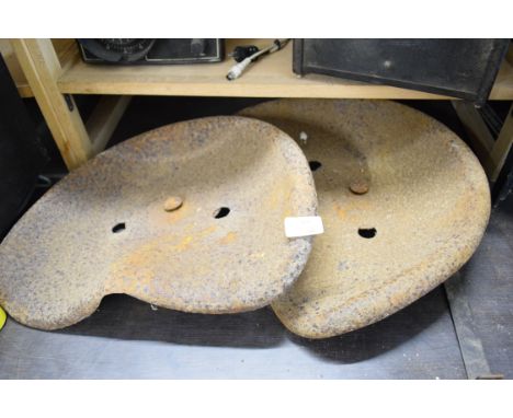 Two metal tractor seats