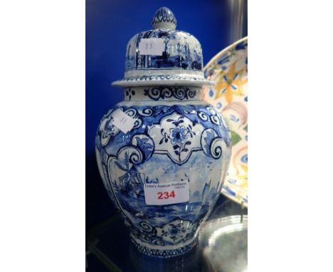 A BLUE AND WHITE GLAZED POTTERY JAR AND COVER IN THE STYLE OF DELFTWARE, 26CM HIGH