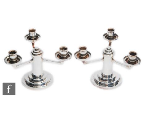H. Mourier - A pair of Art Deco silver plated three light squat candelabra with circular stepped bases, capitals and conformi