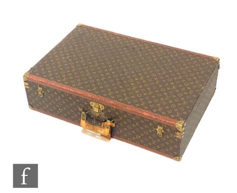 Louis Vuitton - A large Alzer hard case suitcase trunk, monogrammed leather with gold hardware, retains luggage strap and key