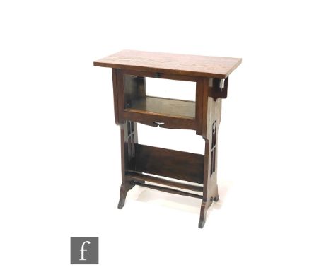 In the manner of Liberty &amp; Co - A small oak cabinet bookcase, the rectangular overhanging top above a glazed fall-front c