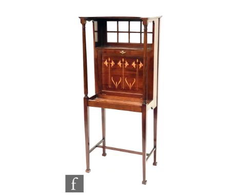 Liberty &amp; Co - A mahogany writing cabinet, the canopy top over a sectional glazed panel and a fall front writing cabinet 