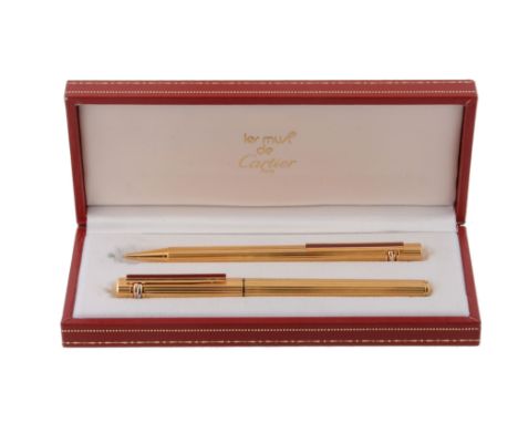  Cartier, Les Must de Cartier, a ballpoint pen and a pencil set,   both with ridged detail and a trinity ring, the ballpoint 