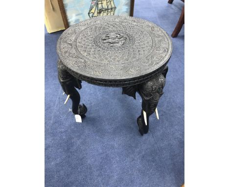 EARLY 20TH CENTURY INDIAN EBONISED CARVED WOOD CIRCULAR TABLE, with elephant head and trunk supports