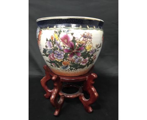 20TH CENTURY CHINESE FLORAL DECORATED PLANTER ON WOODEN STAND along with a Chinese plate and a collection of wooden stands
