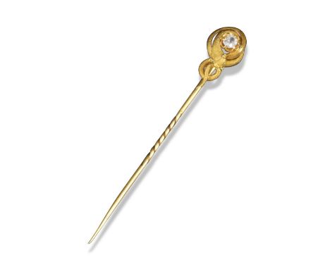 A Victorian gold snake stick pin, c1880, the textured snake is coiled around a cushion-shaped diamond, 7.5cm high