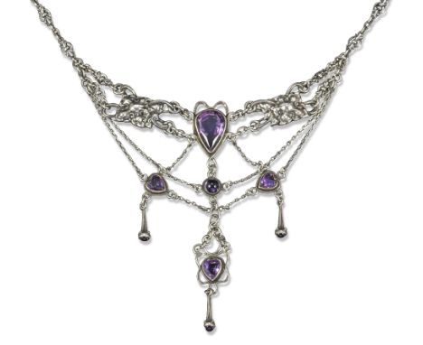 An Arts & Crafts silver and amethyst necklace, c1925, the pear-shaped amethyst set with within floral motif decorated plaques