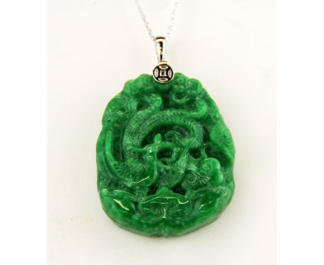 A Chinese carved jade/ hardstone dragon amulet on a 925 silver chain, amulet L. 5cm , chain L. 44cm.