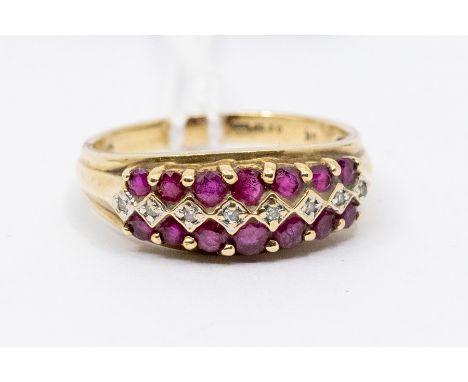  A ruby and diamond 9ct gold ring, comprising a central row of small diamonds set either side with a row if round cut graduat