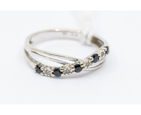 A sapphire and diamond 9ct white gold dress ring, comprising a cross over of alternate diamond and sapphire round cut stones,