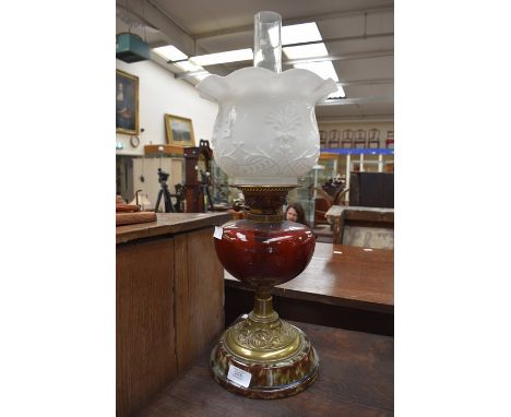 A Victorian ruby glass oil lamp with treacle glaze base and shade