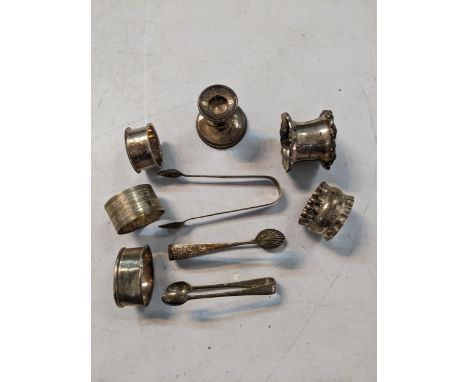 Mixed silver to include five napkin rings, a small dwarf candlestick, and three sugar tongs including a Georgian example, mix