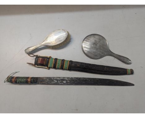 Silver dressing table items to include a machine turned brush and mirror, together with a vintage African dagger and sheathLo