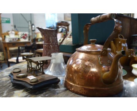 A GRANITEWARE ENAMEL LIDDED MILK JUG, a small Holophane lamp shade, a set of postal scales and a copper kettle 