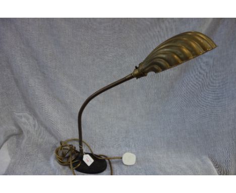 AN IRON BASED FLEXIBLE STEM STUDENT LAMP with brass shell shade