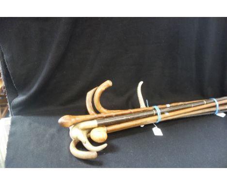 A HORN HANDLED WALKING STICK with a silver collar, similar walking sticks and a hunting crop 