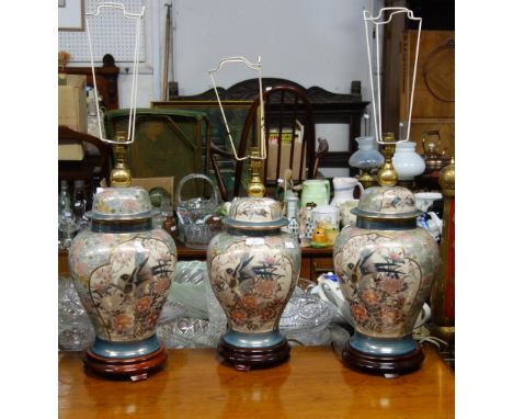 A PAIR OF ORIENTAL CERAMIC TABLE LAMPS in the form of covered vases painted with birds, 44cm high (excluding fitting) and a m