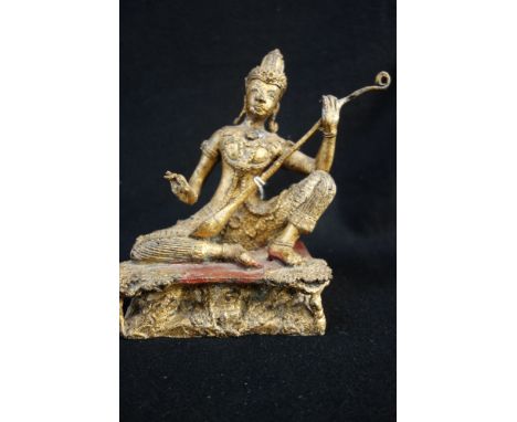 A THAI OR BURMESE GILT-BRONZE FIGURE, seated with one knee raised and playing a stringed instrument, 20th century, 16.5cm hig