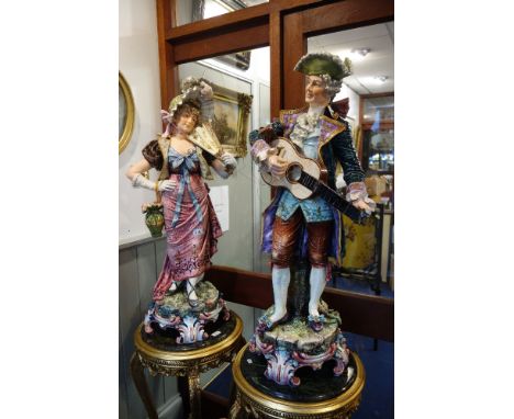 A LARGE PAIR OF 19TH CENTURY CONTINENTAL FIGURES, a musician playing a guitar and a lady with a fan, both in 18th century cos