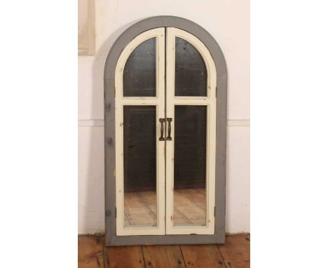 A grey and white painted wall mirror, of arched shape, having shutter doors, h.101 x w.53cm