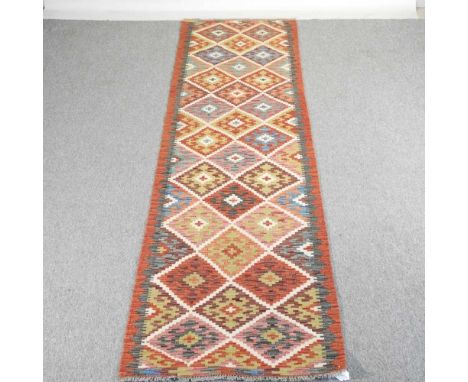 A Turkish kilim runner, decorated with colourful geometric designs, 297 x 80cm