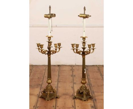 A pair of gilt six branch table candelabra, 19th century, in the Rococo style, each upon a triform base, later converted into