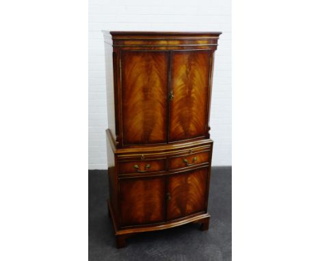 A mahogany drinks cabinet with two cupboard doors above a pull out slide and pair of short drawers with a further two doors t