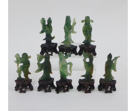 Chinese jade set of eight Immortals, modelled standing on a pierced hardwood base, tallest 6cm (8) 