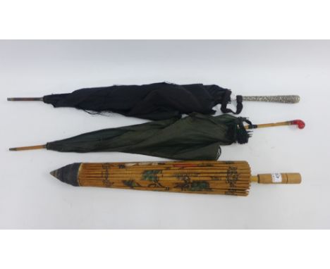 Collection of vintage umbrellas, one with a white metal embossed handle with Elephant pattern, the other with a red agate han