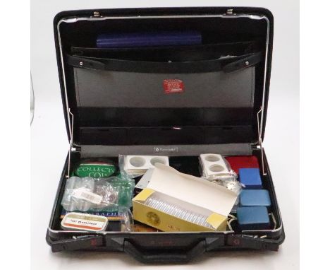 Briefcase populated with coin collecting accessories including scales, magnifier, capsules, flips, reference books, albums an