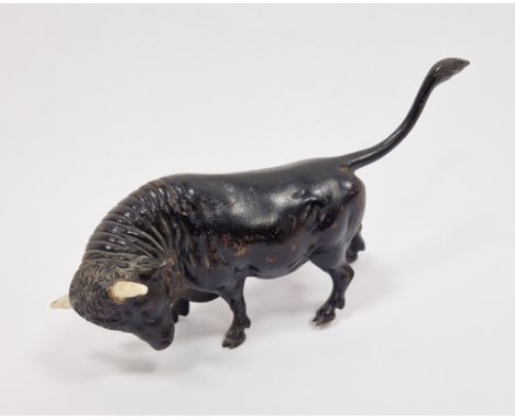 Patinated bronze and bone-mounted miniature model of a bull, 20th century, naturalistically cast with tail raised in charging