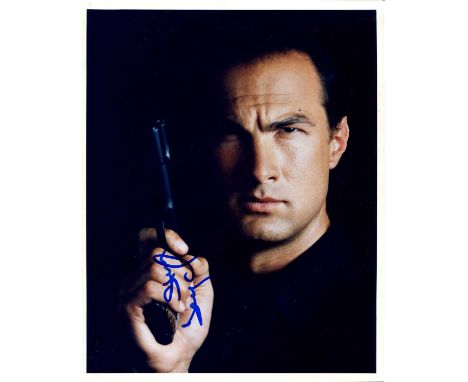 SEAGAL STEVEN: (1952- ) American actor. Signed colour 8 x 10 photograph of Seagal in a head and shoulders pose, holding a rev