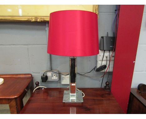 A mirrored table lamp with red shade 