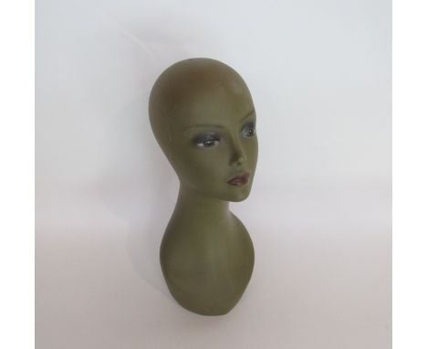 An early 1970's female mannequin head with a long slender neck, khaki ground with muted make-up tones, a/f, 45cm tall 