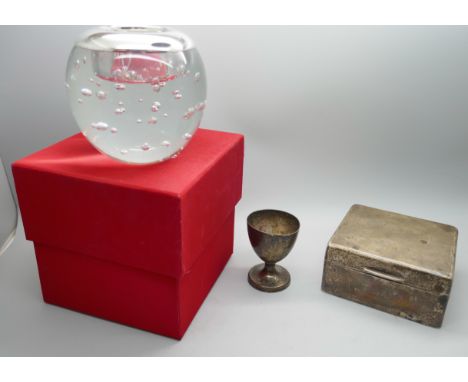 A silver egg cup, a silver cigarette box and silver mounted candle holder