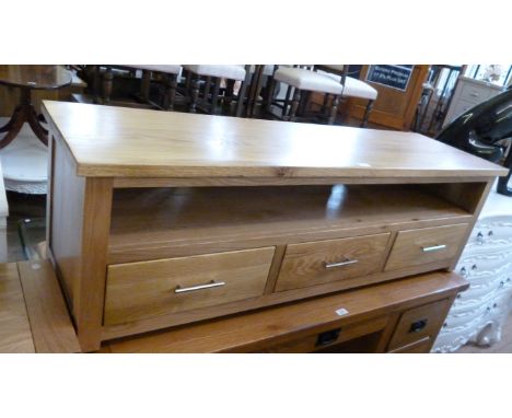 A modern light oak TV cabinet with a rectangular top above an undershelf and three frieze drawers.