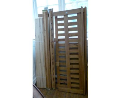 A modern light oak slatted bed and side rails.