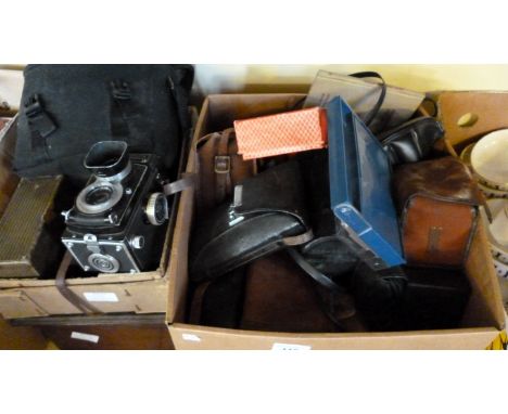 A collection of vintage cameras and camera effects including cased box cameras, camera lenses, Rolleflex and others.