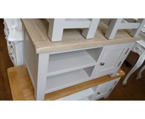 A modern bleached oak and painted TV stand with a single cupboard door brushed metal handle.